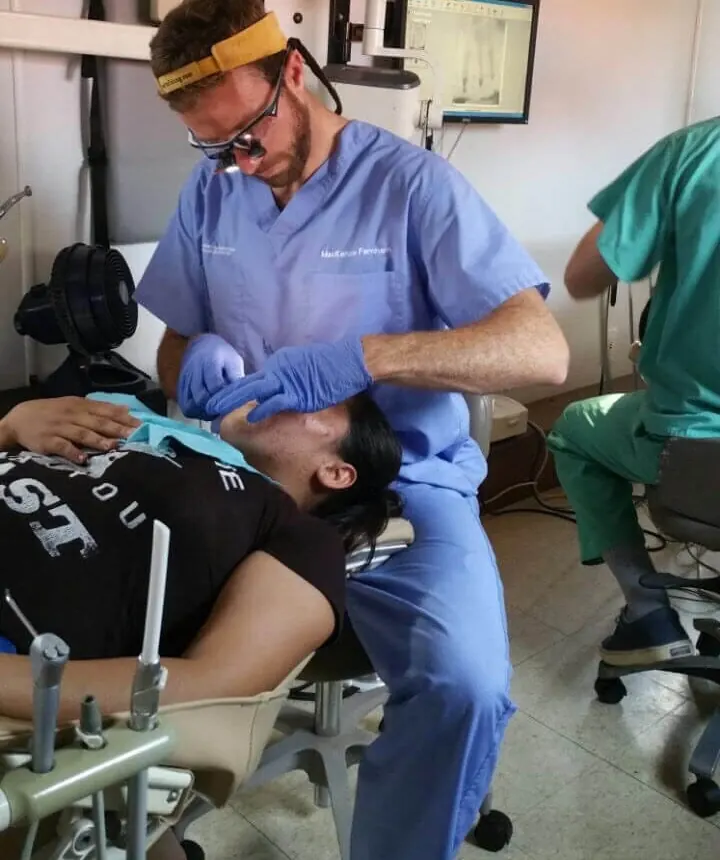 A dentist treating a patient in a field clinic during the El Salvador dental mission.