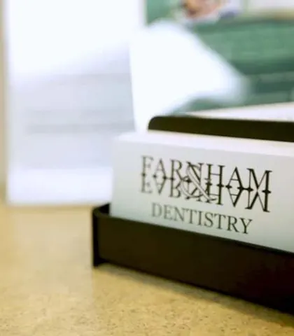 Farnham Dentistry business cards in a holder on the front desk.