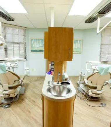 Two treatment rooms with dental chairs, seen from the corridor.