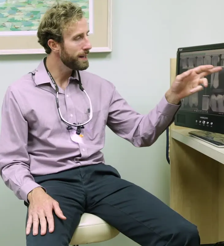 Dr. MacKenzie Farnham in a treatment room, pointing to images on a monitor.